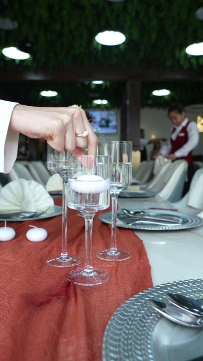 A dining table laid with candles in warm, raking light.