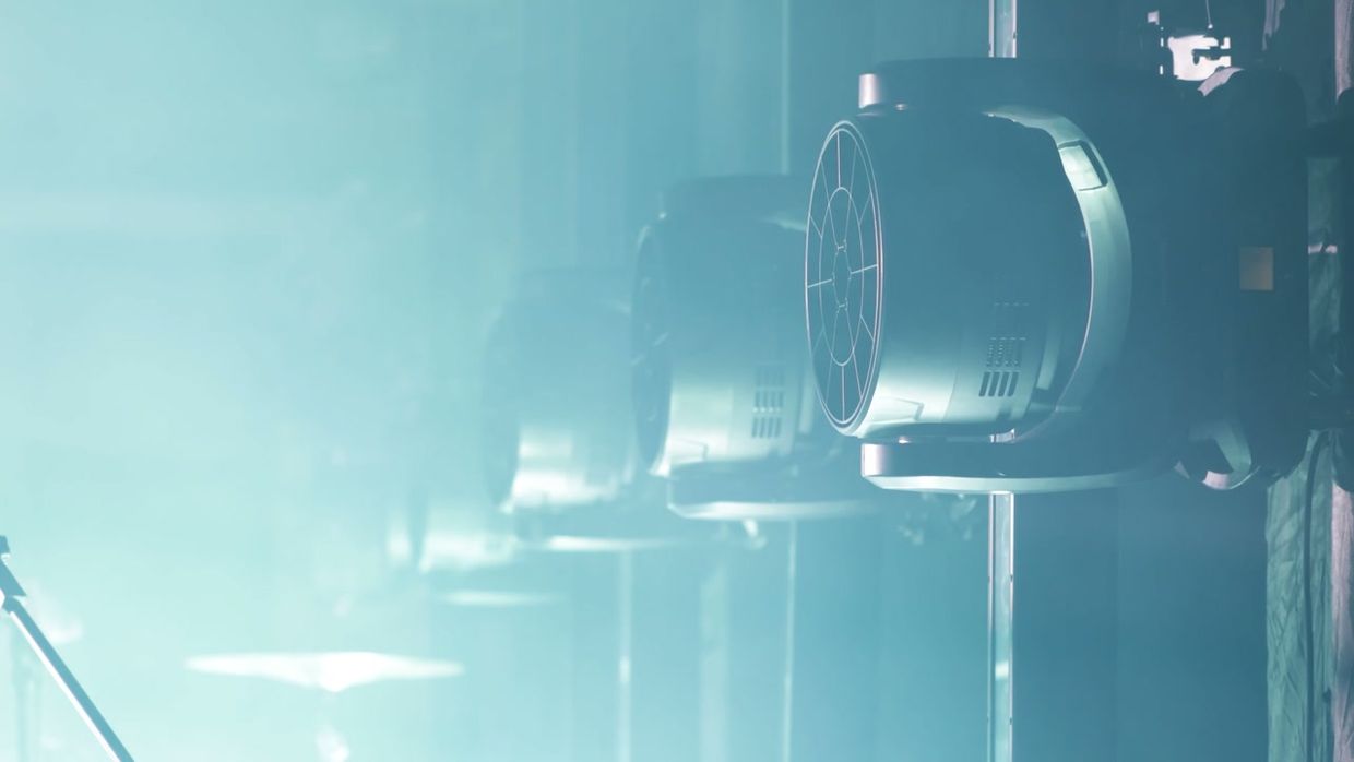 Stage lighting cutting through haze above a conference set.