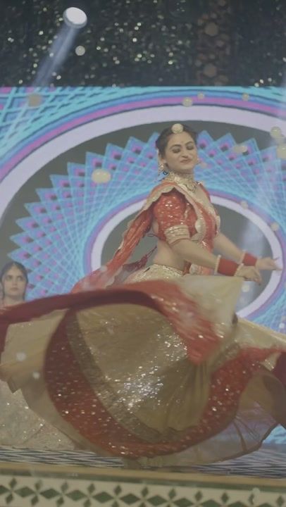 A traditional Indian dance costume in motion under stage light.
