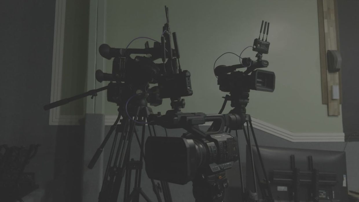 Broadcast cameras set up in a studio.