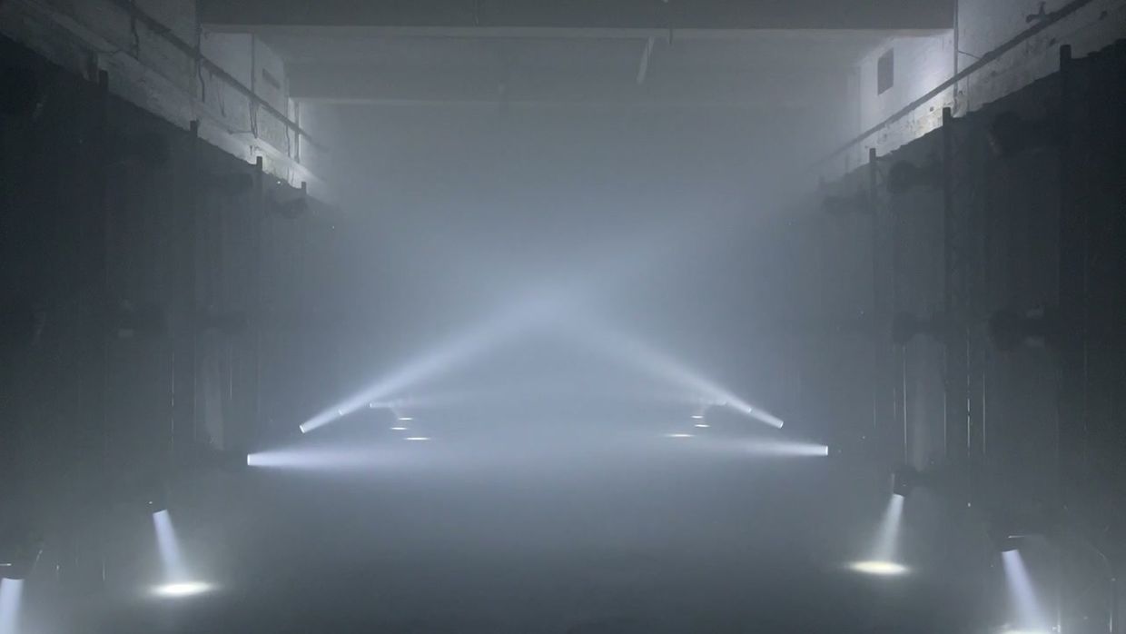 Beams of light cutting through haze in a dark corridor.